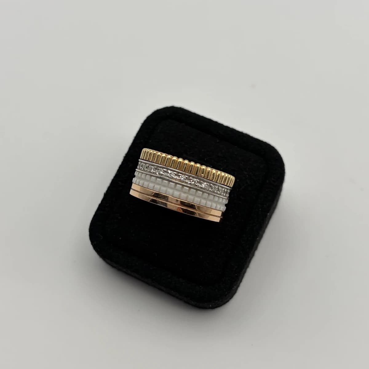 Front view of the Boucheron Quatre Classic ring showing its gold, white ceramic, and diamond bands