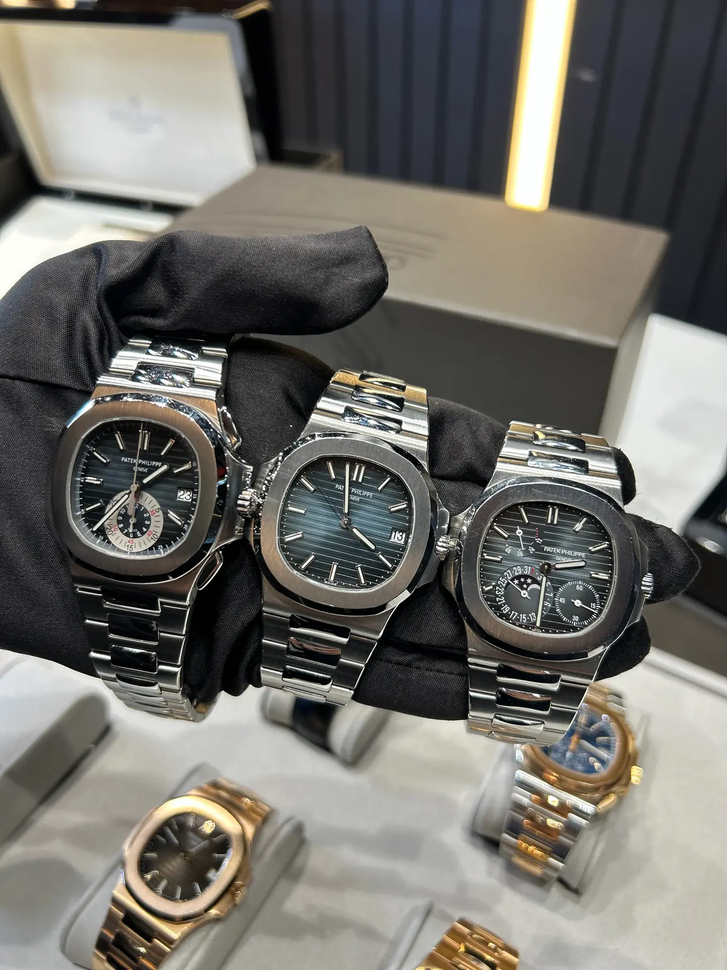 Three Patek Philippe Nautilus watches handled with gloves during inspection