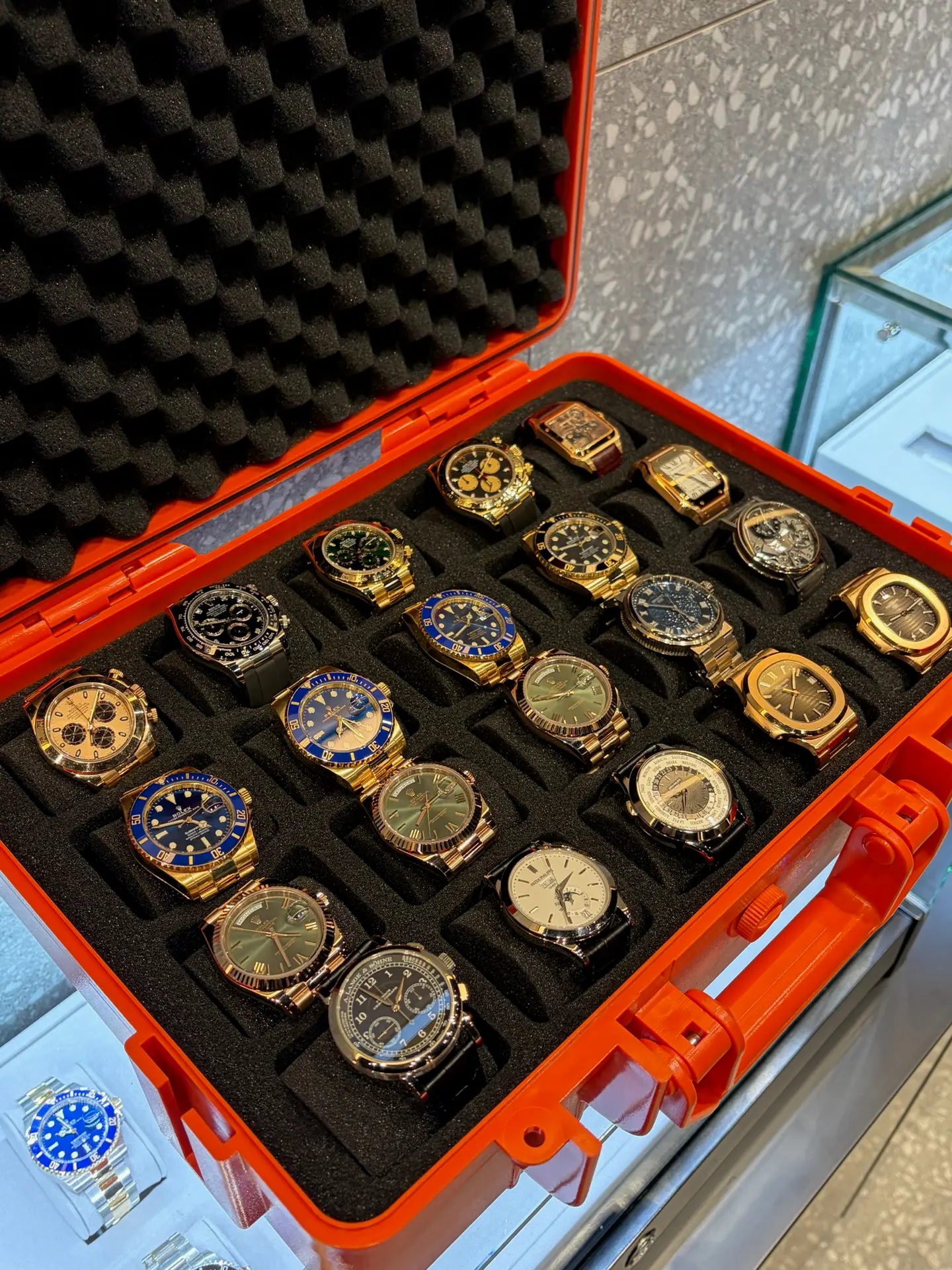 A case of pre-owned luxury watches including Rolex, Patek Philippe and Cartier