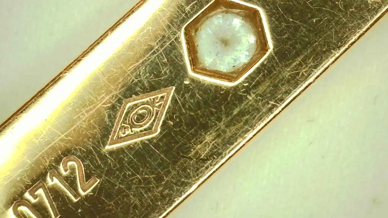 Cartier workshop mark and diamond setting examined under magnification