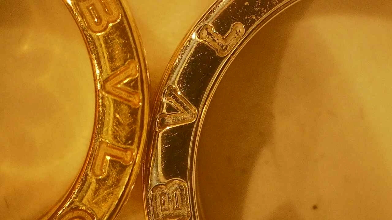 Bulgari engravings compared under magnification, genuine on the left and counterfeit on the right