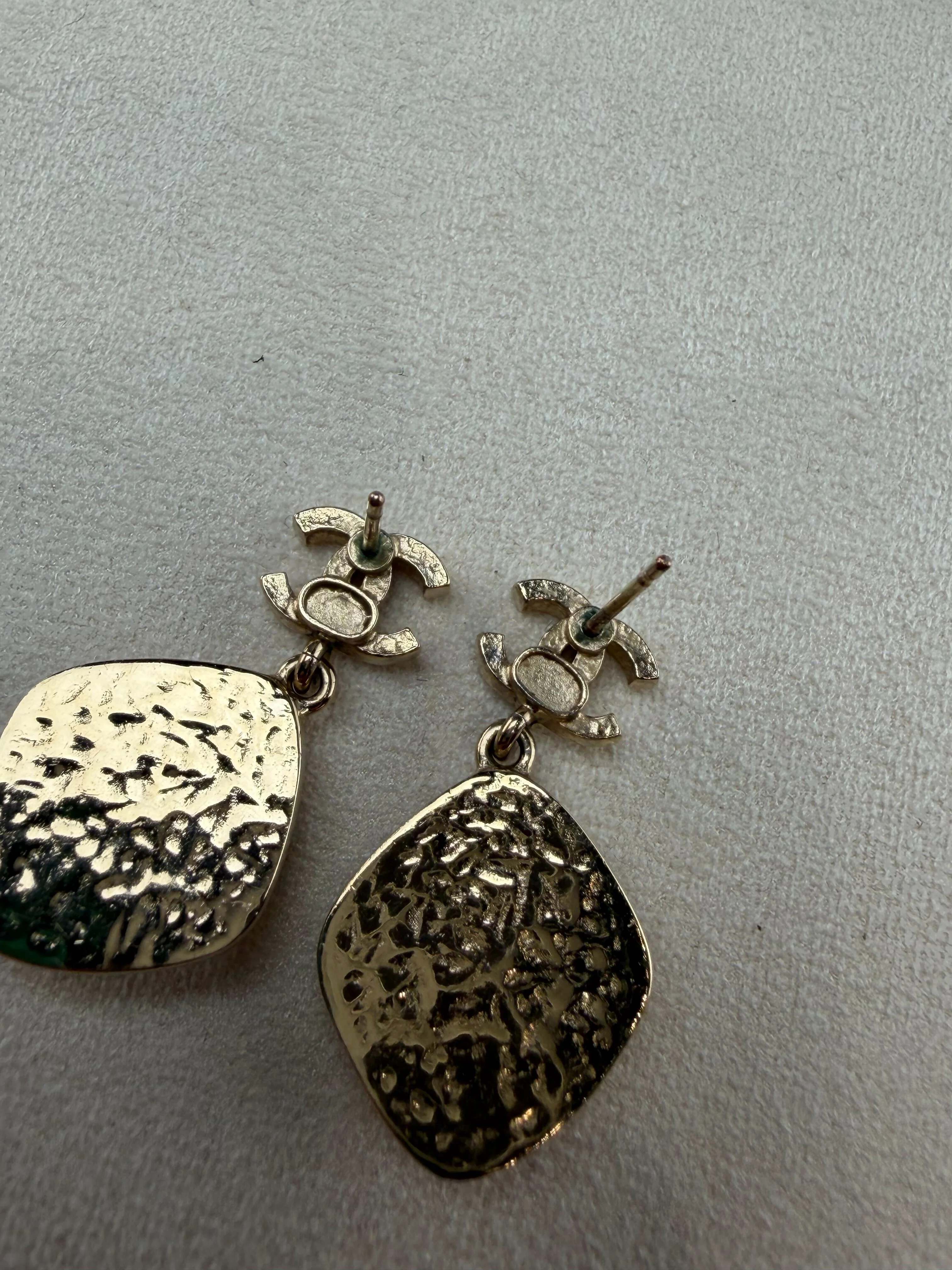 Chanel costume jewelry drop earrings showing the metal plate stamped with the Chanel logo
