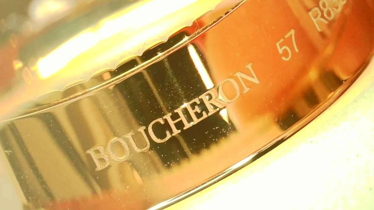 Macro photo of a genuine Boucheron Quatre ring hallmark, engraved "BOUCHERON 57"