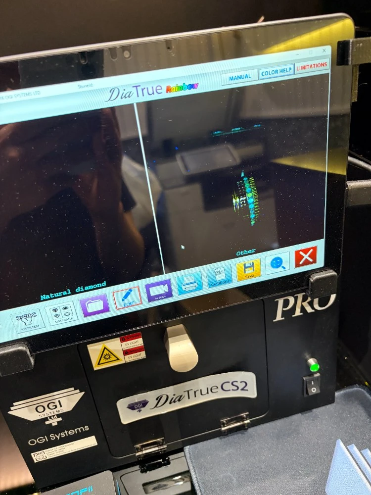 OGI Systems DiaTrue CS2 professional diamond-screening device mid-scan, reading "Natural diamond"