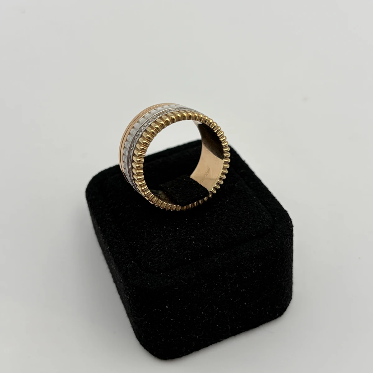 Boucheron Quatre Classic ring standing on its edge on a black velvet ring box