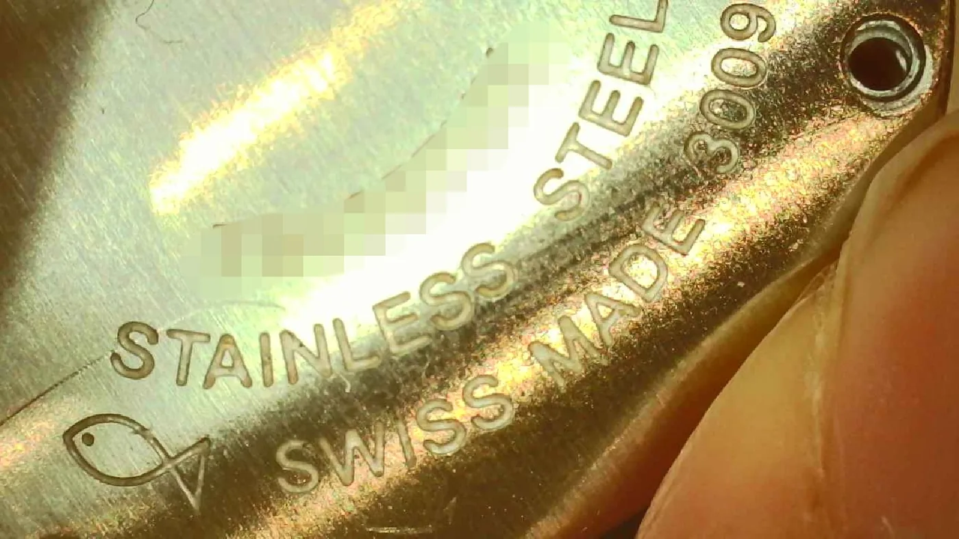 Close-up of the case back engraving reading Stainless Steel, Swiss Made, and the reference number, serial number blurred