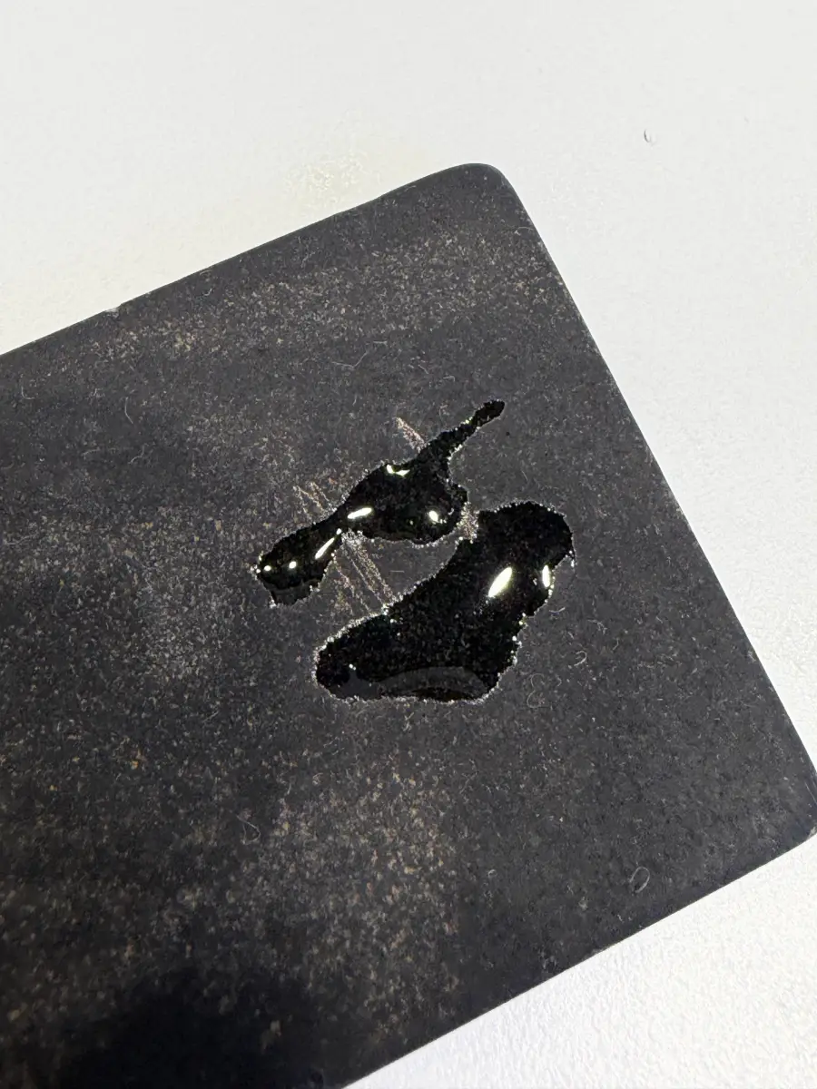 Touchstone with drops of 18K testing solution that did not wear away