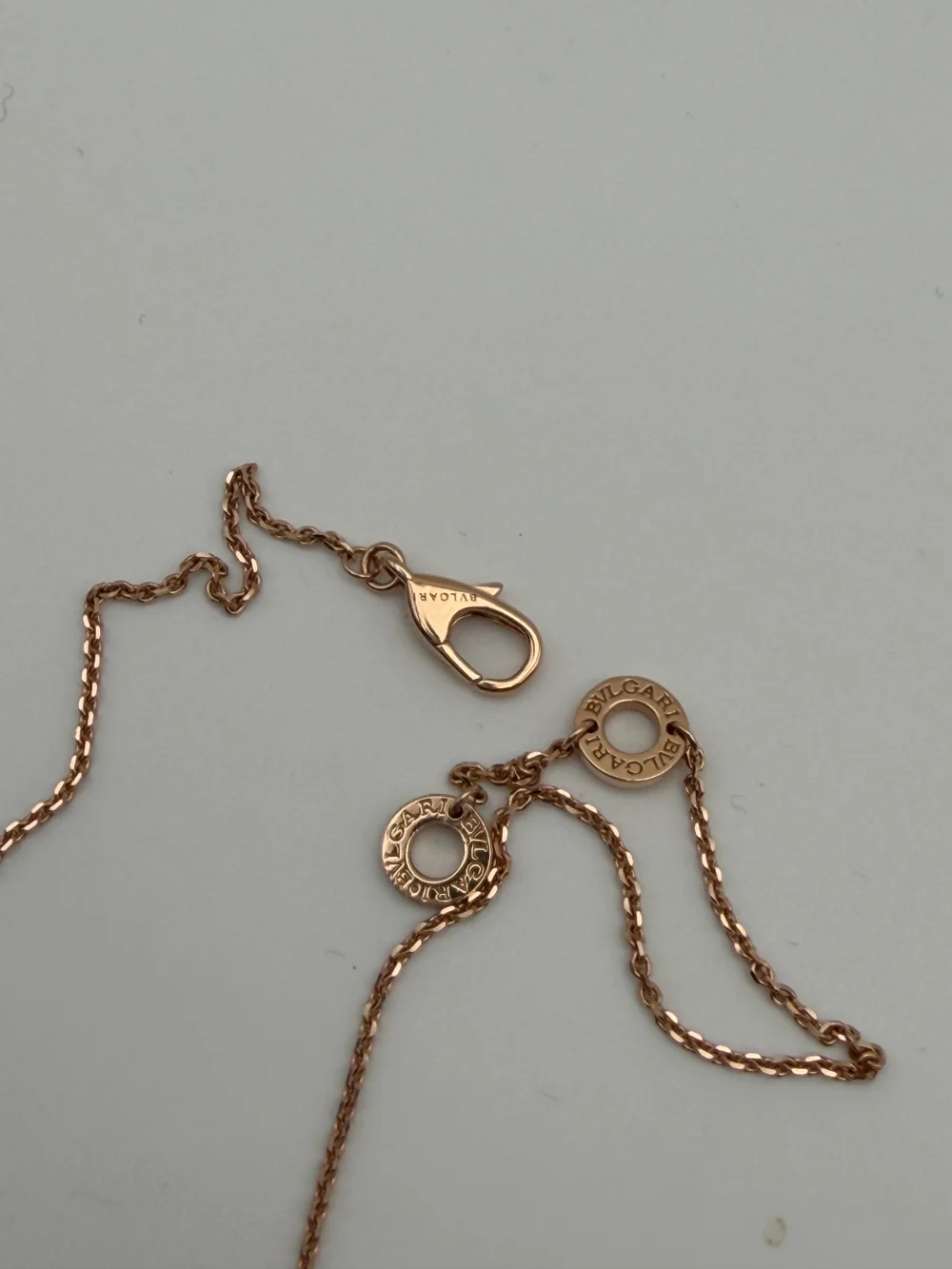 Clasp end of the counterfeit necklace showing two small BVLGARI discs on the chain