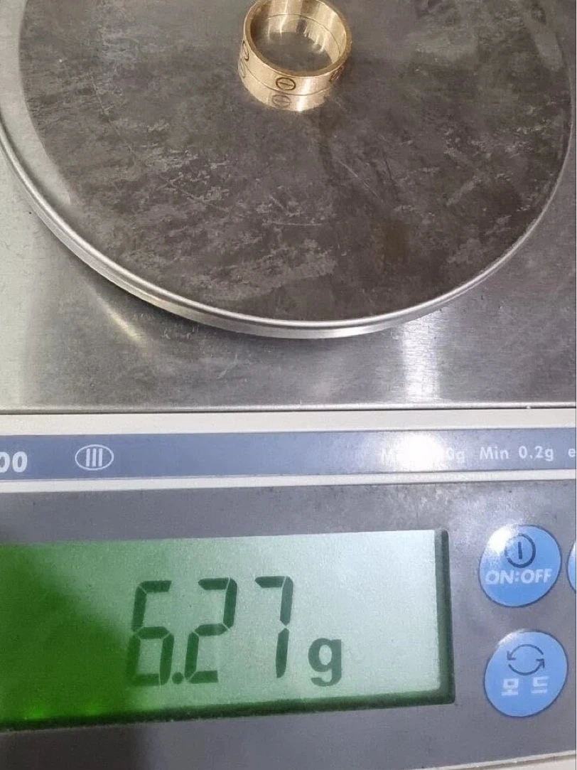 Men's Cartier Love ring, size 57, on a precision scale before polishing, reading 6.27 g